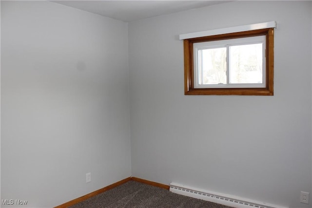 carpeted empty room featuring a baseboard heating unit