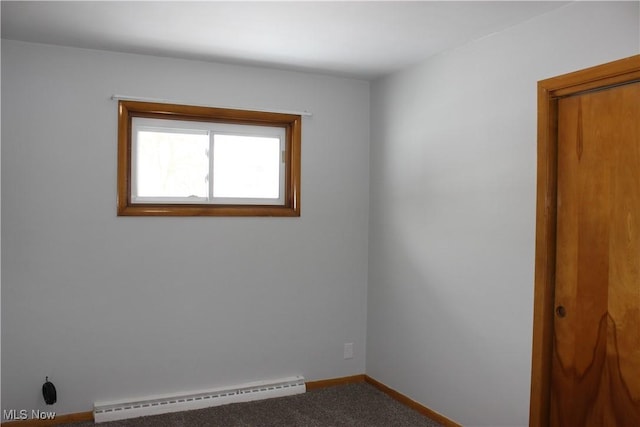 empty room with carpet floors, baseboards, and baseboard heating