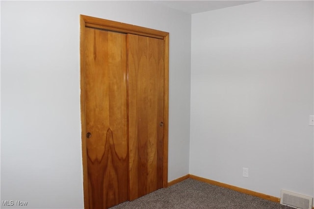 unfurnished bedroom with a closet, baseboards, visible vents, and carpet flooring