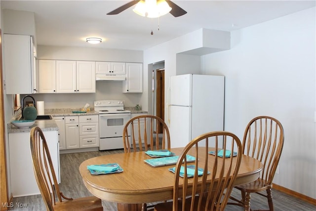 kitchen featuring under cabinet range hood, white appliances, a sink, white cabinetry, and light countertops