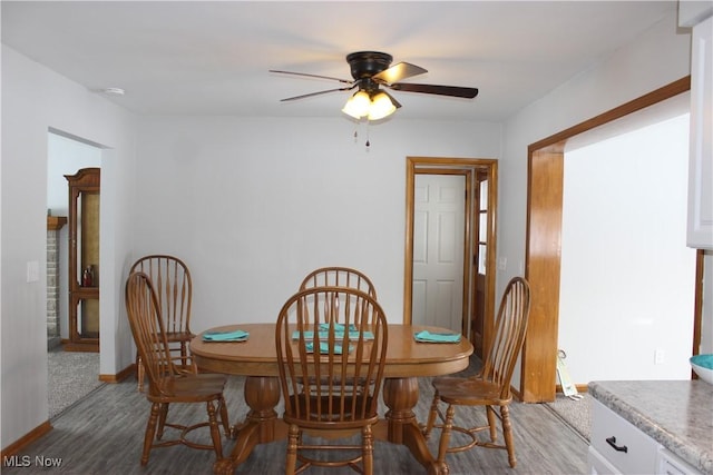 dining room featuring a ceiling fan, baseboards, and wood finished floors