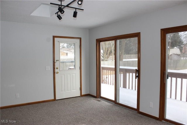 doorway to outside featuring carpet floors, visible vents, and baseboards