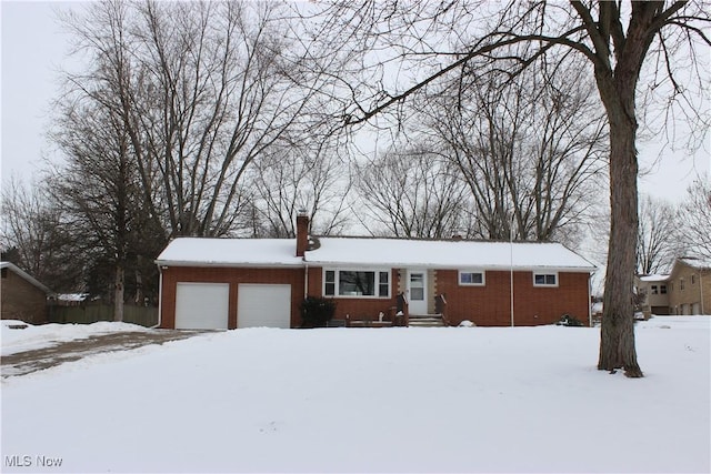 ranch-style home featuring a garage, brick siding, and a chimney