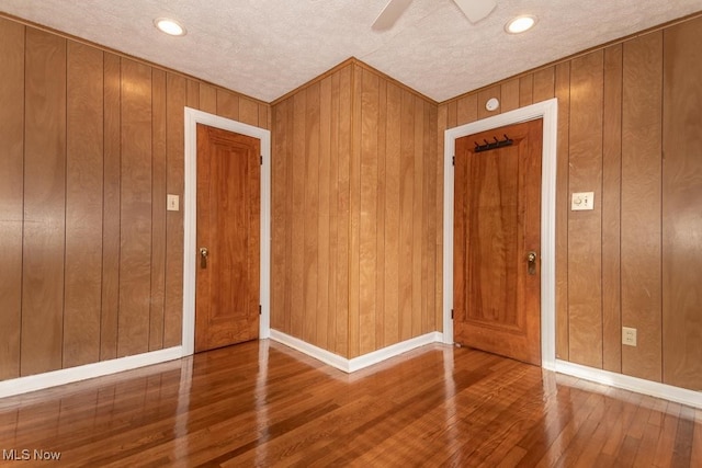 foyer entrance featuring ceiling fan, wood-type flooring, and a textured ceiling