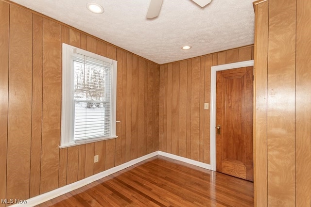 empty room with hardwood / wood-style floors, a textured ceiling, and ceiling fan