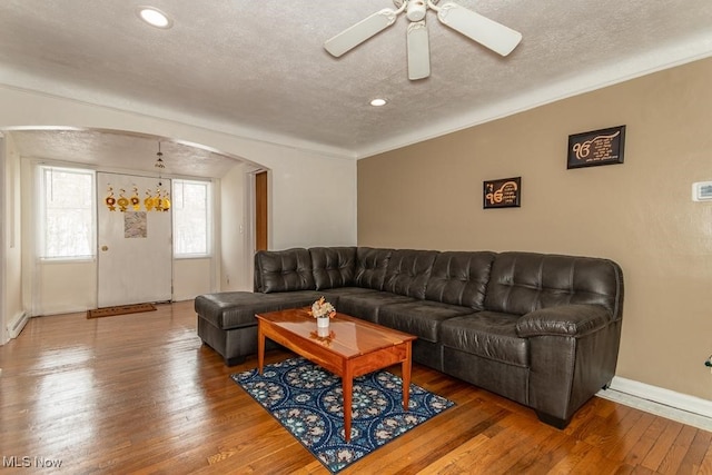 living room featuring ceiling fan, wood-type flooring, and a textured ceiling