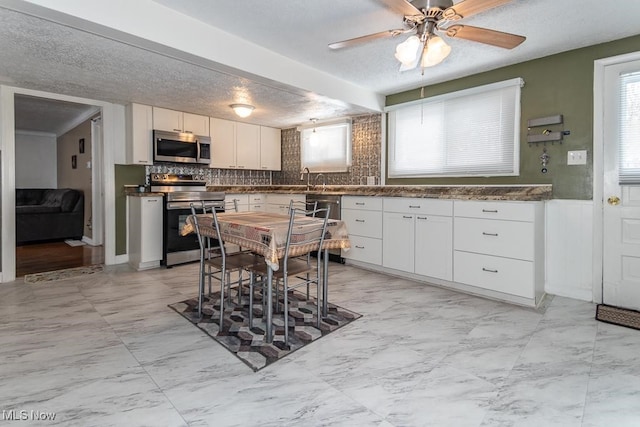 kitchen with a healthy amount of sunlight, white cabinetry, and appliances with stainless steel finishes