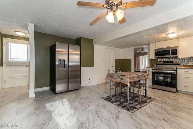 kitchen with ceiling fan, backsplash, and appliances with stainless steel finishes