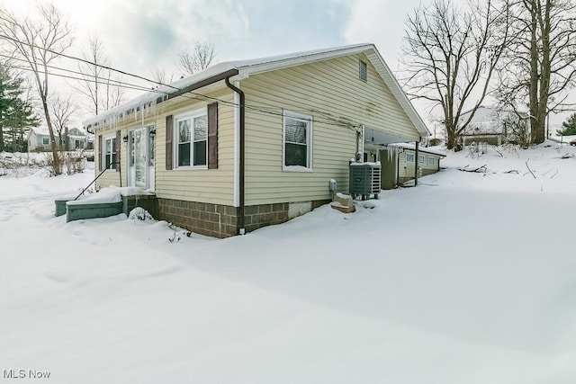 view of snowy exterior with central AC