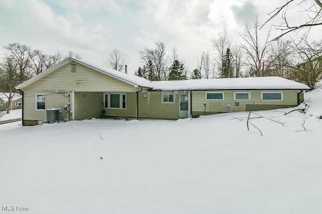 snow covered back of property with central air condition unit