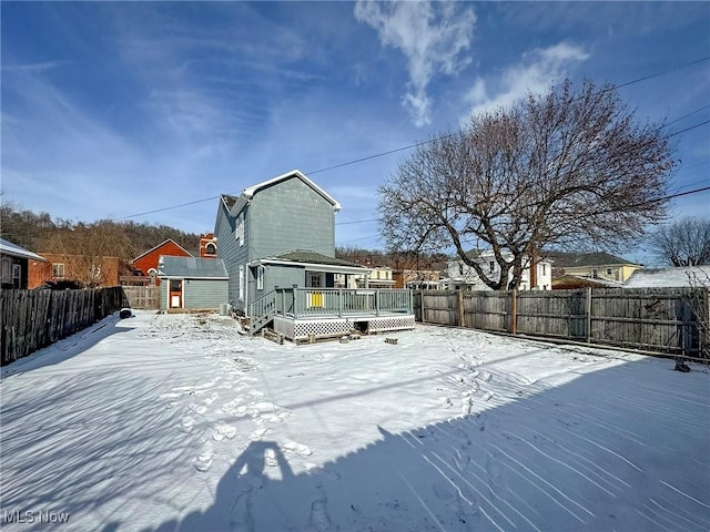 snow covered rear of property featuring a deck