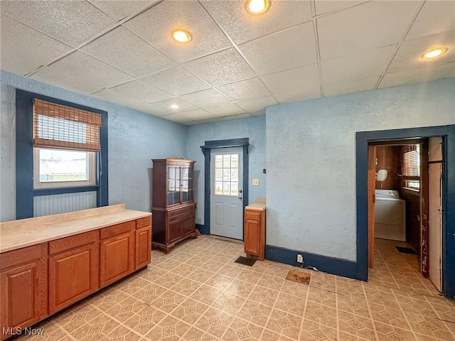 bathroom with a drop ceiling and washer / dryer