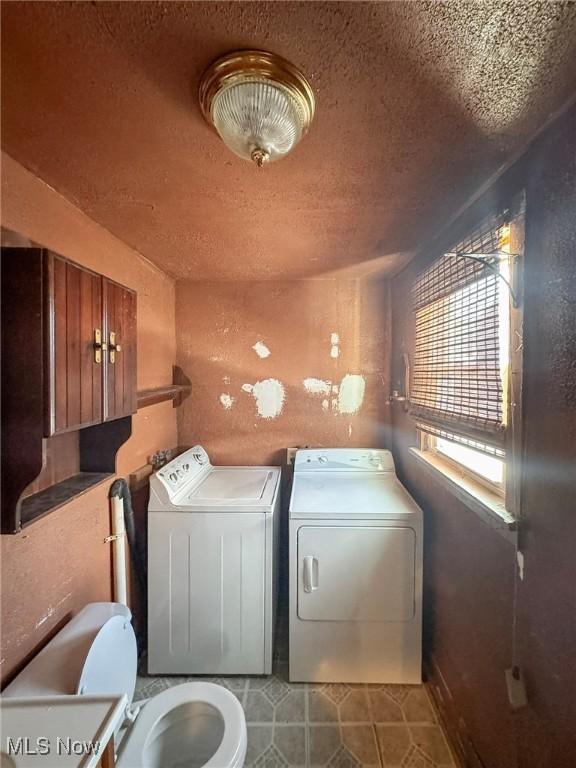 laundry area with a textured ceiling and independent washer and dryer