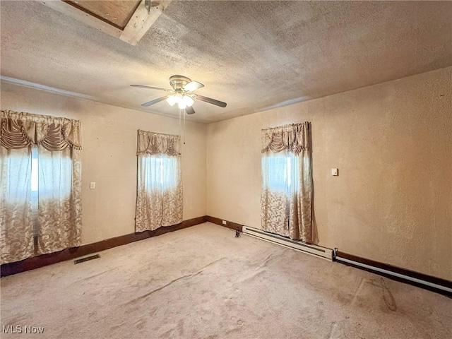 carpeted spare room with baseboard heating, a textured ceiling, and ceiling fan