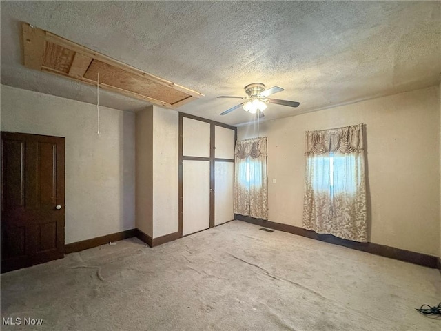 carpeted empty room featuring ceiling fan and a textured ceiling