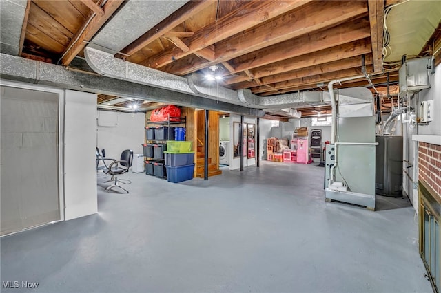 basement featuring washer / clothes dryer, water heater, and heating unit