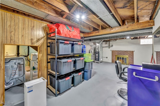 basement featuring heating unit and wood walls