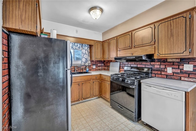 kitchen with white dishwasher, sink, gas stove, backsplash, and stainless steel fridge