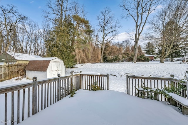 snow covered deck featuring a shed