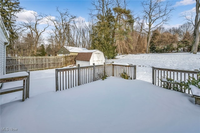 snow covered deck featuring a shed