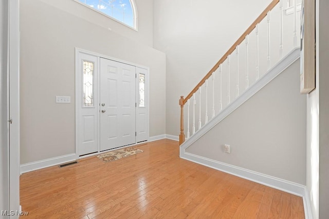 foyer featuring light hardwood / wood-style flooring and a towering ceiling