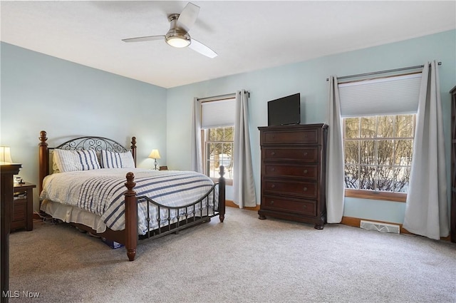 carpeted bedroom featuring multiple windows and ceiling fan