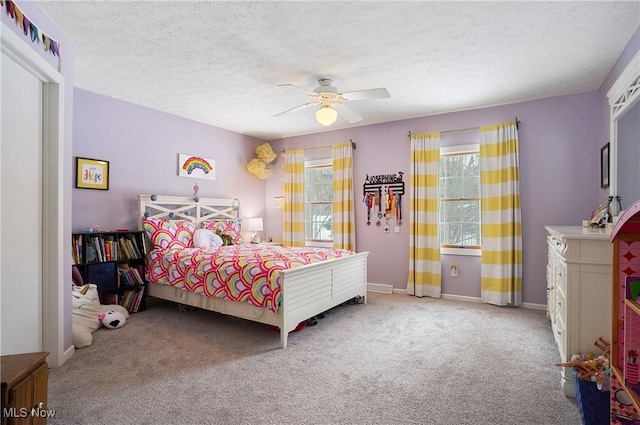 carpeted bedroom with ceiling fan and a textured ceiling