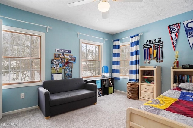 carpeted bedroom featuring ceiling fan and a textured ceiling