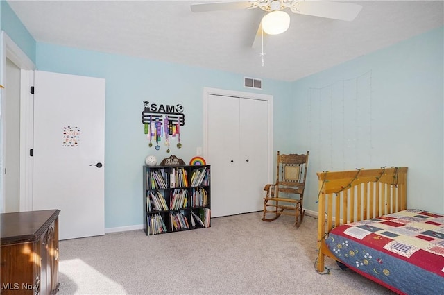 bedroom with a closet, ceiling fan, and light colored carpet