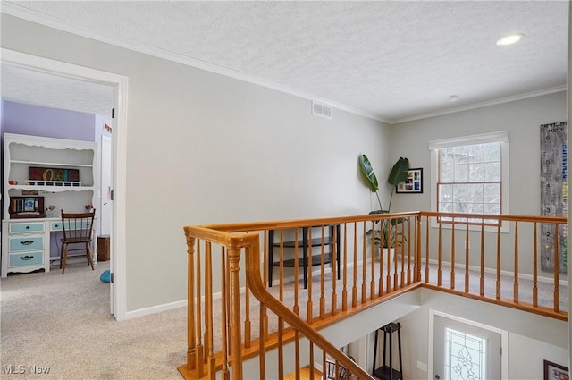 hall featuring a textured ceiling, crown molding, and light carpet