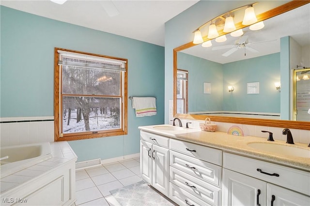 bathroom featuring tile patterned flooring, ceiling fan, plenty of natural light, a bathing tub, and vanity