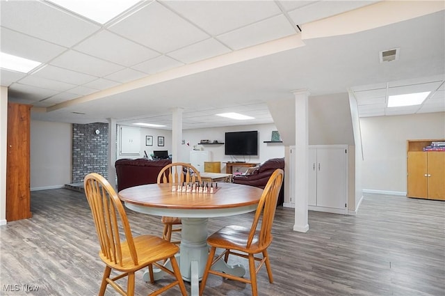 dining room featuring hardwood / wood-style flooring and a drop ceiling