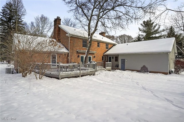 snow covered house with a wooden deck