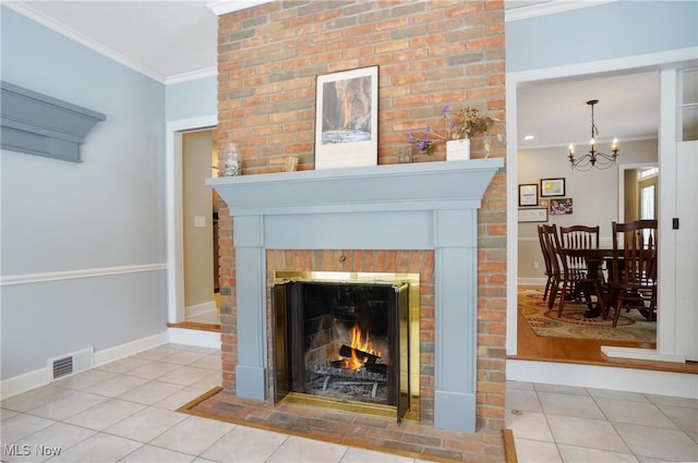 details featuring ornamental molding, a notable chandelier, and a fireplace