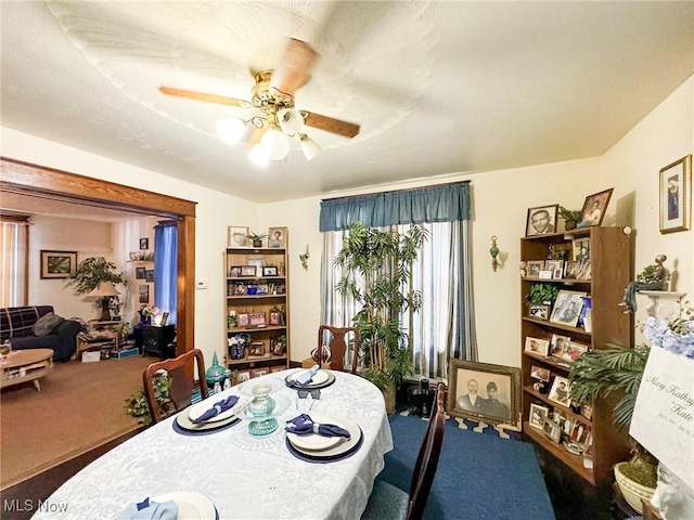 dining space with ceiling fan and carpet flooring