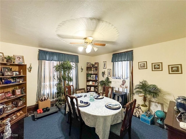 carpeted dining space with ceiling fan, plenty of natural light, and a textured ceiling