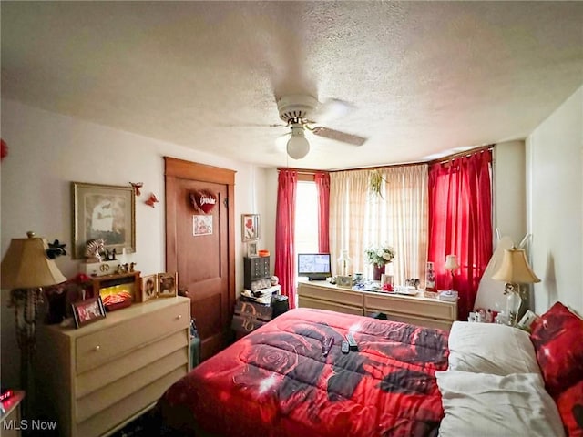 bedroom with a textured ceiling and ceiling fan