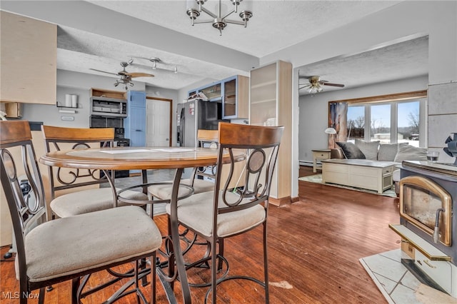 dining space featuring ceiling fan, hardwood / wood-style floors, and a textured ceiling