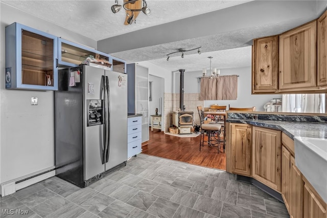 kitchen with decorative light fixtures, a textured ceiling, baseboard heating, and stainless steel refrigerator with ice dispenser