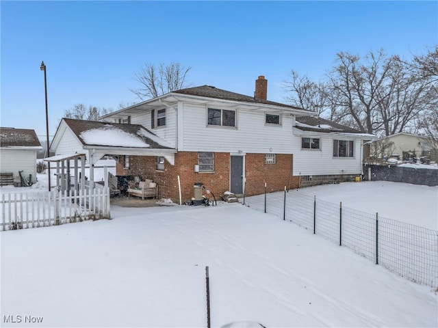 view of snow covered rear of property