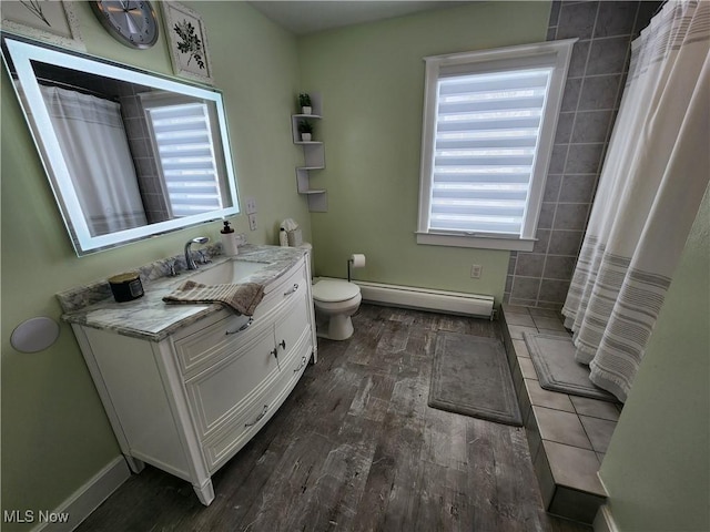 bathroom featuring vanity, toilet, walk in shower, and a baseboard heating unit