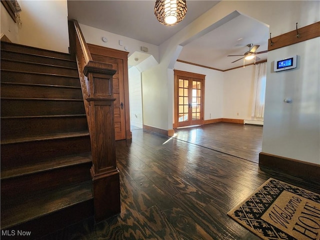 interior space with crown molding, a baseboard heating unit, french doors, ceiling fan, and dark hardwood / wood-style floors