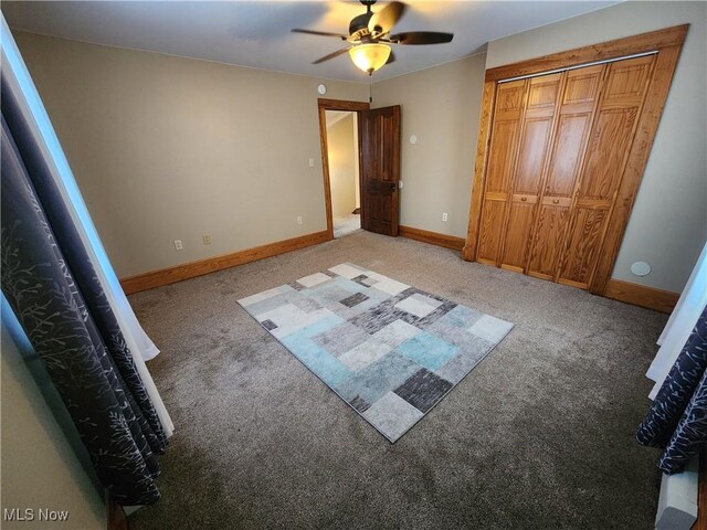 unfurnished bedroom with a closet, ceiling fan, and carpet flooring