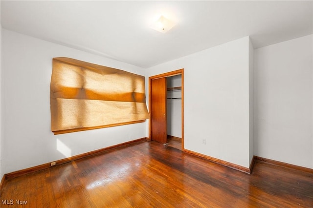 unfurnished bedroom with wood-type flooring and a closet