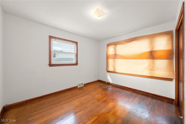 spare room featuring dark wood-type flooring