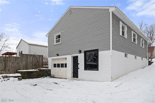 snow covered property featuring a garage