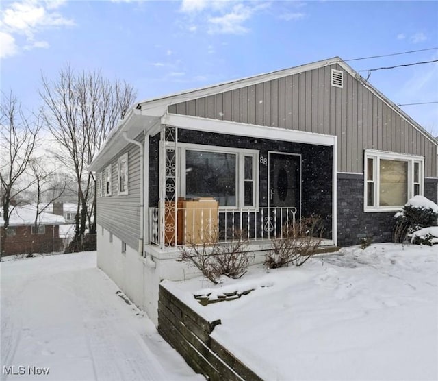 view of snowy exterior with covered porch