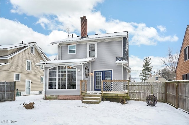 snow covered rear of property featuring an outdoor fire pit