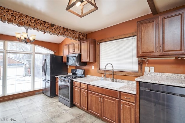 kitchen featuring black appliances, a notable chandelier, light stone countertops, light tile patterned floors, and sink