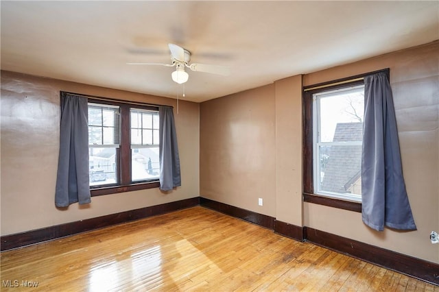 empty room with light wood-type flooring, ceiling fan, and plenty of natural light